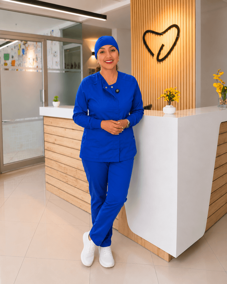Dra. Jennifer Cáceres con uniforme clínico azul en la recepción